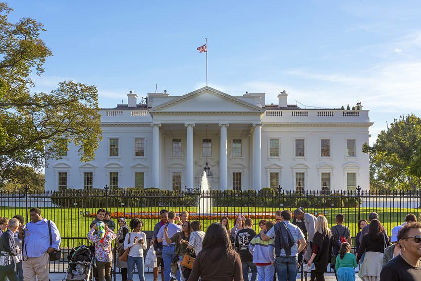 Los visitantes se pararon frente a las puertas de metal para fotografiar la Casa Blanca y la fuente frente a la casa.
